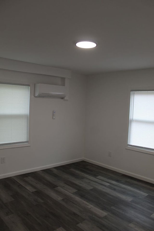 spare room with dark hardwood / wood-style flooring and a wall mounted AC