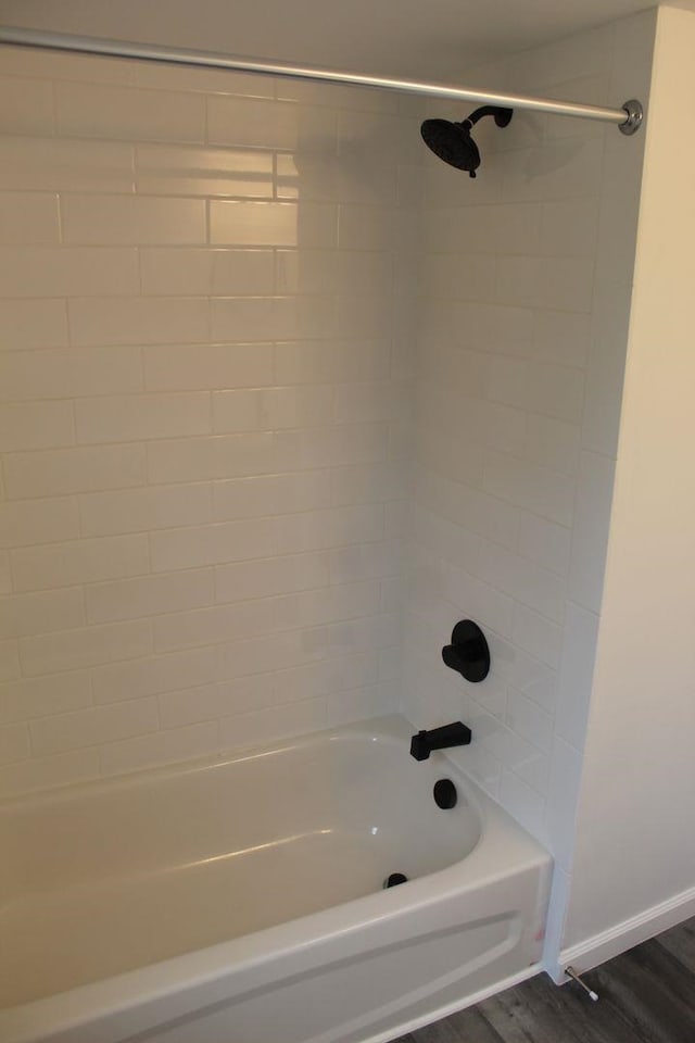 bathroom featuring wood-type flooring and tiled shower / bath