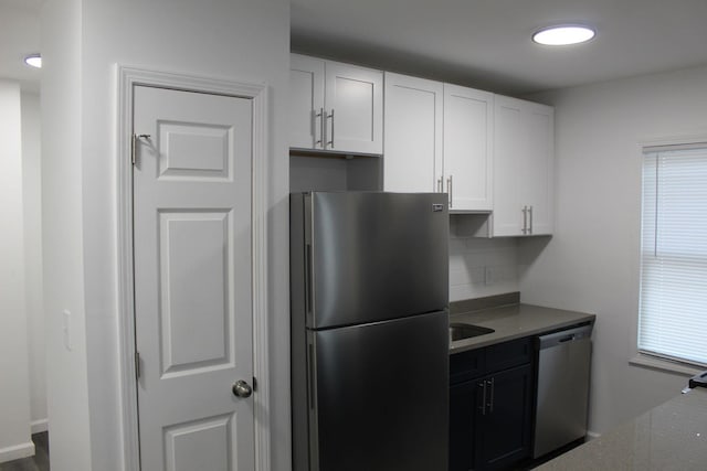 kitchen featuring white cabinets, sink, appliances with stainless steel finishes, and tasteful backsplash