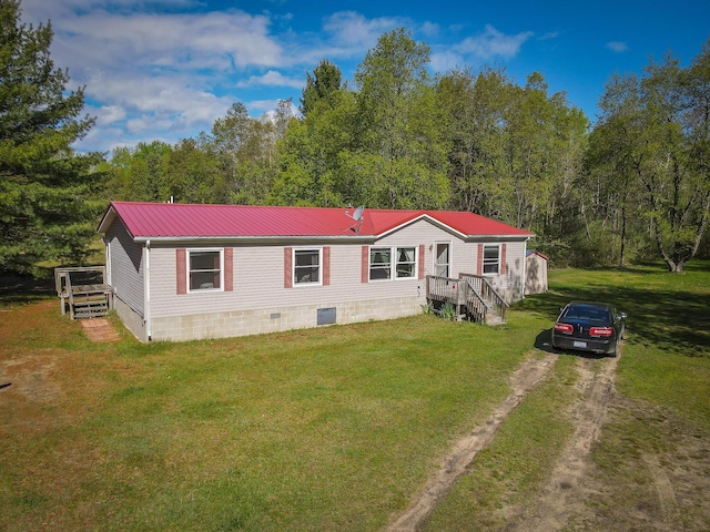 2314 Revolt Rd, Manistee, MI 49660 - manufactured / mobile home with metal roof, a front yard, crawl space, driveway, and a wooded view