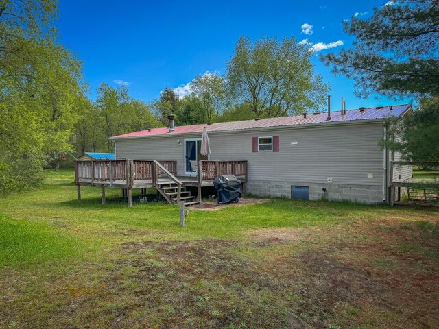 2314 Revolt Rd, Manistee, MI 49660 - rear view of property with a deck, a yard, and metal roof