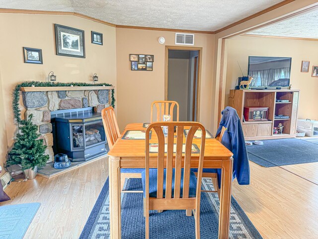 2314 Revolt Rd, Manistee, MI 49660 - dining room with wood finished floors, a textured ceiling, and ornamental molding