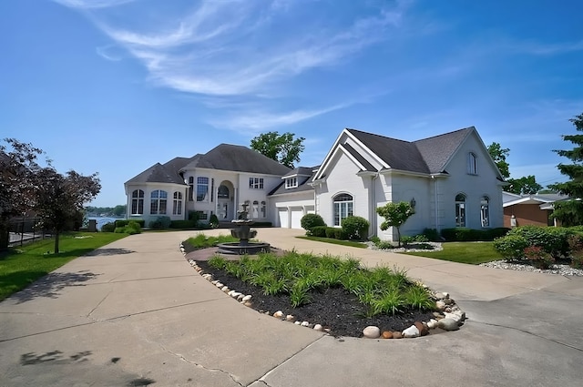 french country style house featuring a front yard and a garage