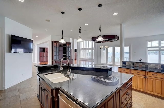 kitchen featuring stainless steel dishwasher, decorative light fixtures, light tile patterned floors, and sink