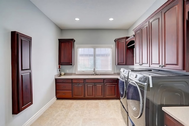 laundry room featuring cabinets, independent washer and dryer, and sink