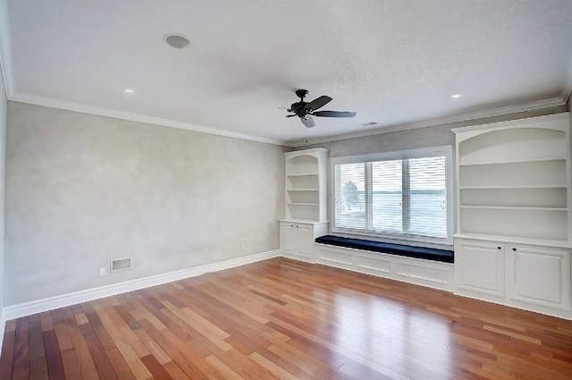 spare room with ceiling fan, light wood-type flooring, and crown molding