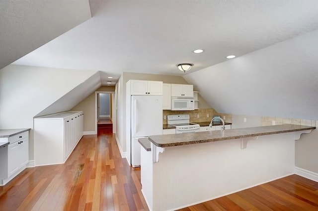 kitchen featuring white cabinets, light hardwood / wood-style floors, white appliances, and kitchen peninsula