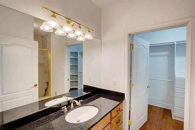 bathroom featuring vanity, a shower with shower door, and wood-type flooring