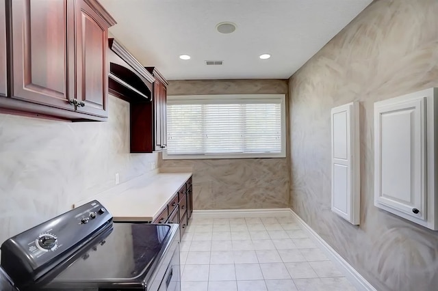 clothes washing area with light tile patterned floors