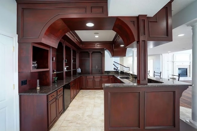 bar with ornate columns, dark stone countertops, and sink