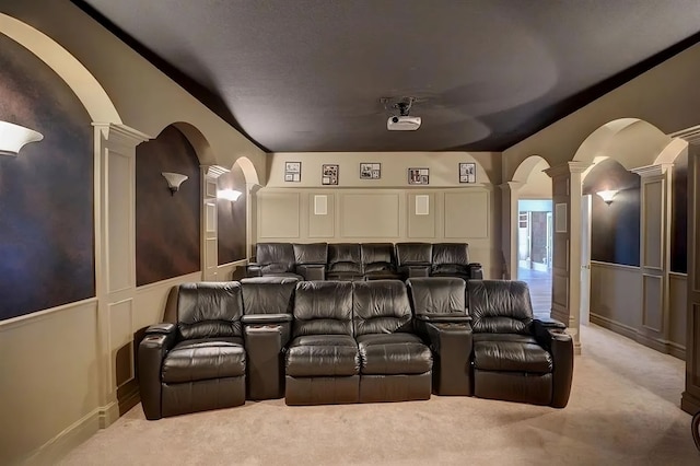 carpeted home theater room with decorative columns