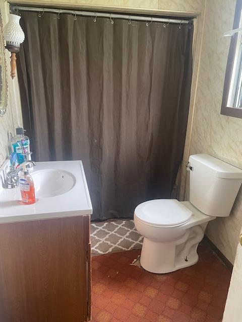 621 E Michigan Ave, Grass Lake, MI 49240 - full bath with vanity, toilet, tile patterned floors, and curtained shower