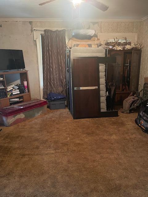 carpeted bedroom featuring ceiling fan and crown molding