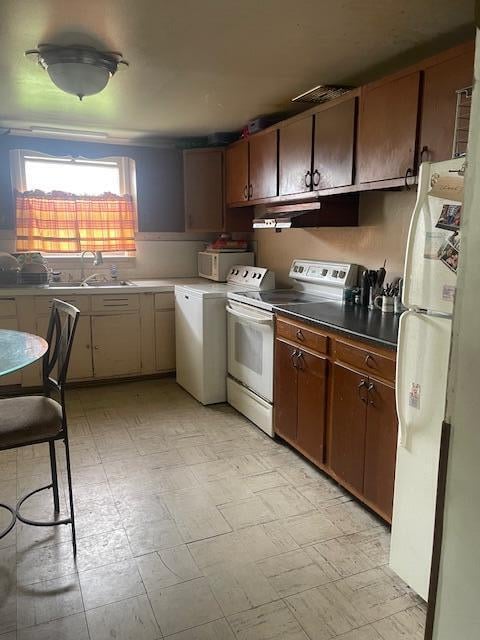 kitchen featuring washer / dryer, white appliances, and sink