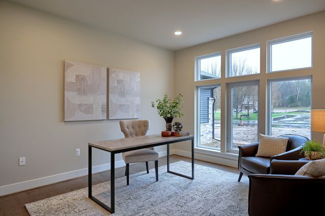 office with light hardwood / wood-style flooring and a healthy amount of sunlight