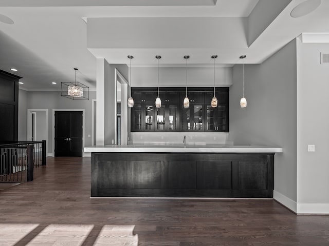 bar with dark hardwood / wood-style flooring and decorative light fixtures