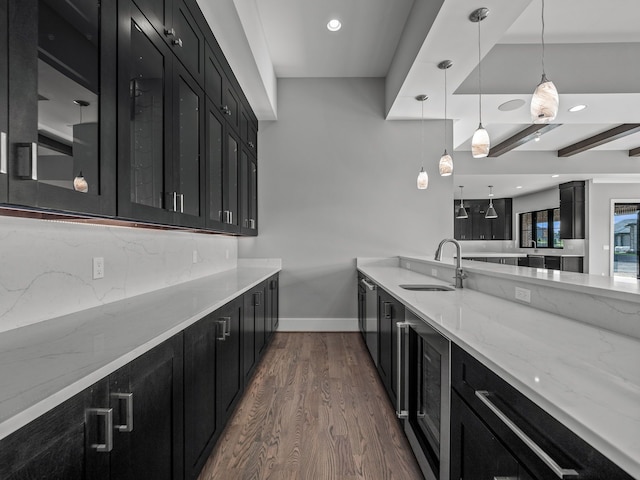 kitchen with decorative backsplash, dark wood-type flooring, sink, beam ceiling, and decorative light fixtures