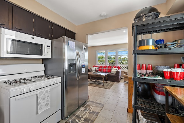 kitchen featuring dark brown cabinetry, white appliances, and light tile patterned floors