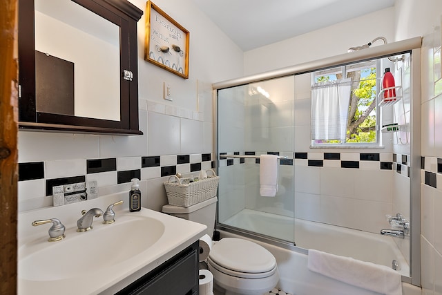 full bathroom with shower / bath combination with glass door, vanity, tile walls, and toilet