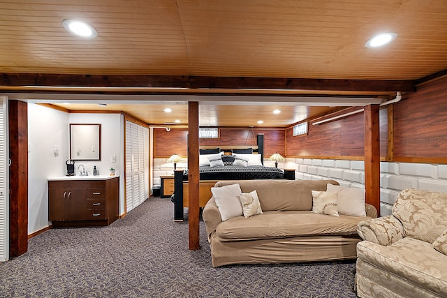 carpeted bedroom with wooden walls and wooden ceiling