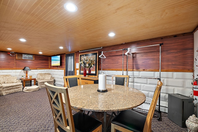 carpeted dining space featuring wooden ceiling and wooden walls