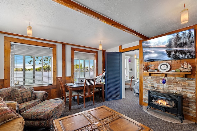 carpeted living room with beamed ceiling, wood walls, a wood stove, and a textured ceiling