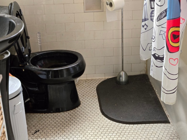 bathroom featuring tile patterned flooring and tile walls