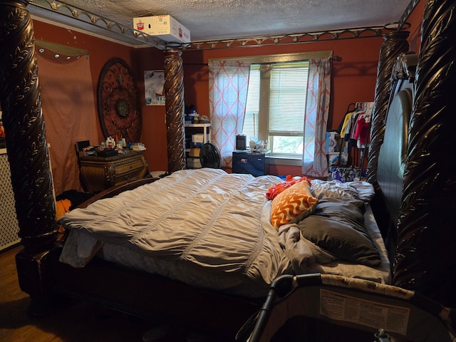 bedroom featuring a textured ceiling and hardwood / wood-style flooring