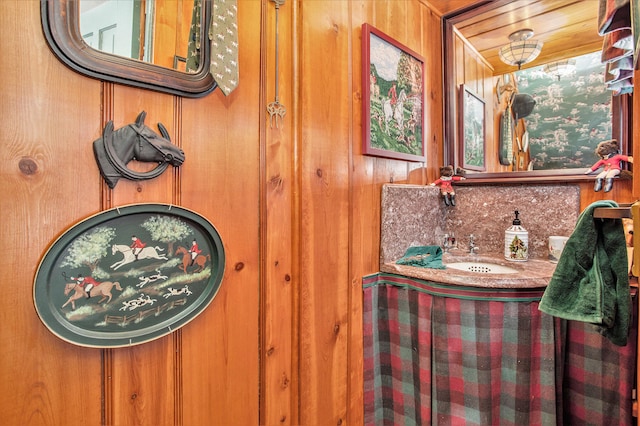 bathroom featuring wooden walls and vanity