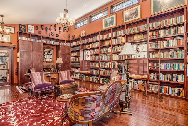 sitting room with a chandelier, lofted ceiling, and hardwood / wood-style flooring