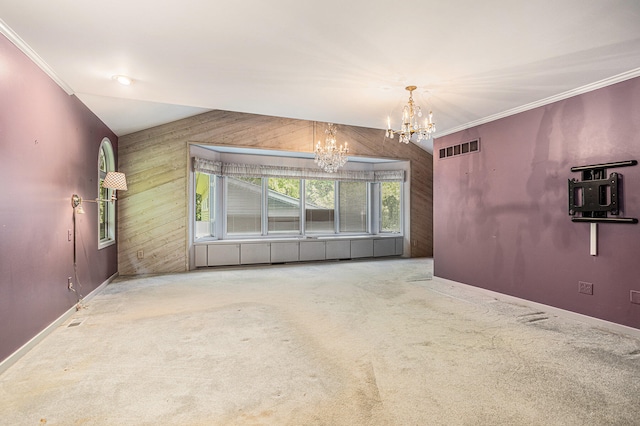 unfurnished room with carpet flooring, an inviting chandelier, crown molding, and wood walls