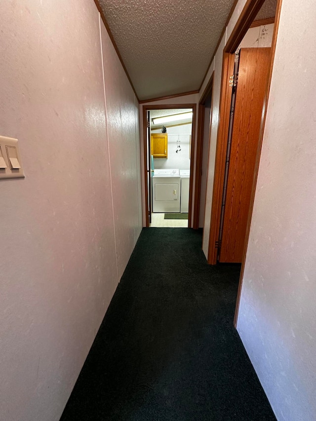 corridor featuring independent washer and dryer, carpet floors, a textured ceiling, and vaulted ceiling