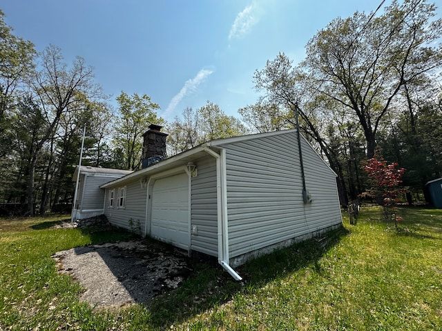 view of side of property featuring a garage and a yard