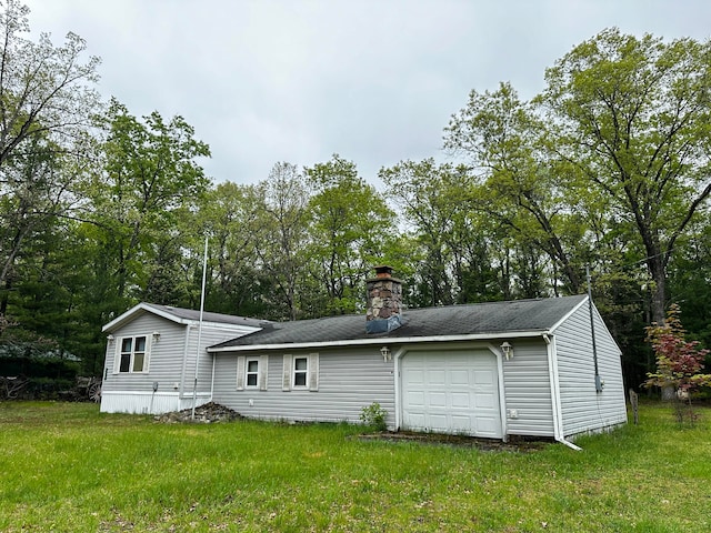 back of house featuring a yard and a garage