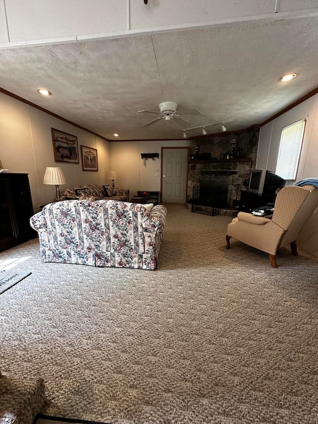 living room featuring carpet flooring, a stone fireplace, ceiling fan, and a textured ceiling