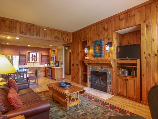 12328-UNIT335B Crystal Mountain Dr, Thompsonville, MI 49683 - living room with wooden walls, light wood-style flooring, and a fireplace