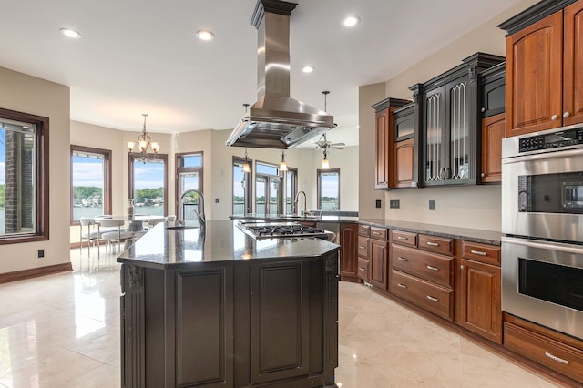 kitchen featuring pendant lighting, stainless steel appliances, plenty of natural light, and island range hood