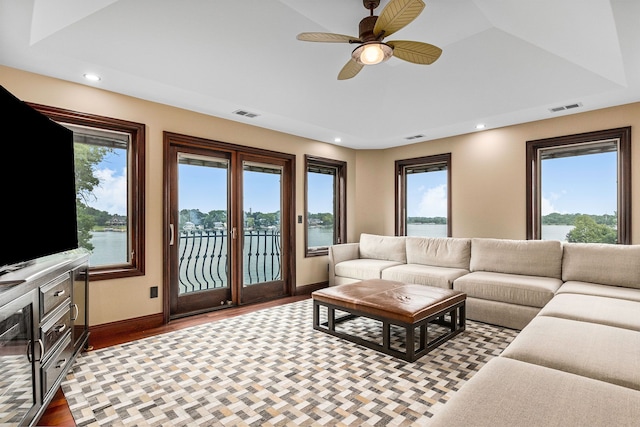 living room with a water view, ceiling fan, and light hardwood / wood-style floors