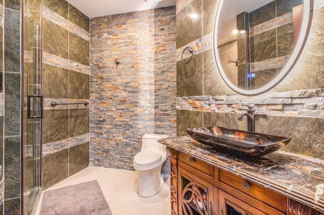 bathroom with vanity, tile patterned flooring, toilet, tile walls, and an enclosed shower