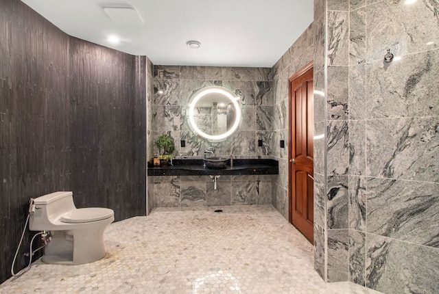 bathroom with toilet, tile walls, and sink