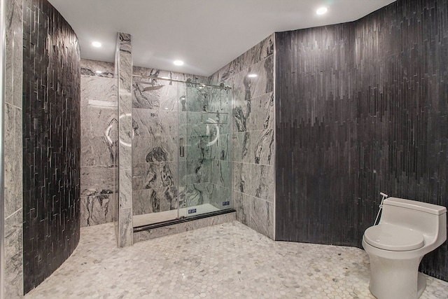 bathroom featuring tile patterned floors, toilet, tile walls, and walk in shower