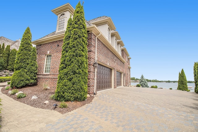 view of side of property with a garage and a water view