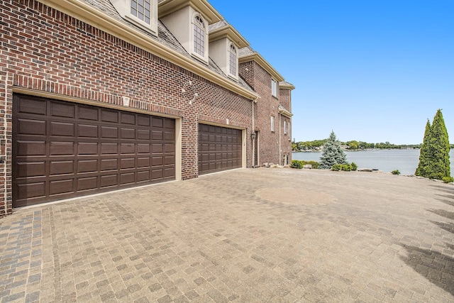 view of side of home with a garage and a water view