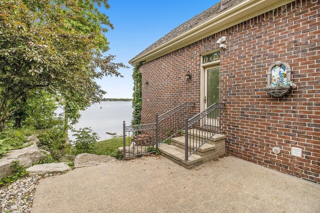 75 Chateaux Du Lac, Fenton, MI 48430 - entrance to property featuring a patio, brick siding, and a water view