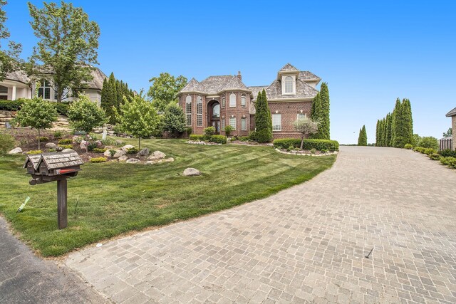 75 Chateaux Du Lac, Fenton, MI 48430 - english style home featuring a front lawn, brick siding, and driveway