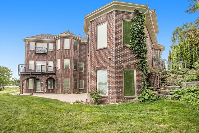 75 Chateaux Du Lac, Fenton, MI 48430 - rear view of property featuring brick siding, a yard, a patio, and a balcony