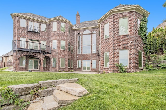 75 Chateaux Du Lac, Fenton, MI 48430 - view of front of house with a front yard, brick siding, a chimney, and a balcony