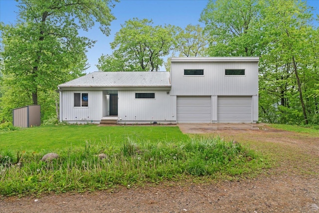 back of property featuring a yard and a garage