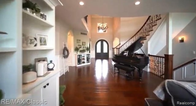 entryway featuring arched walkways, recessed lighting, wood finished floors, stairs, and french doors