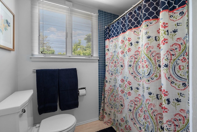 bathroom with toilet, a shower with shower curtain, and hardwood / wood-style flooring